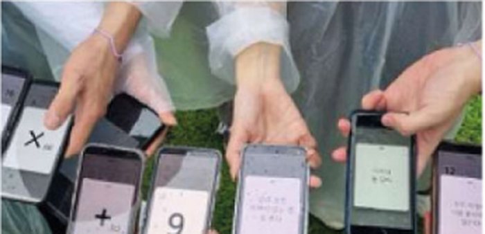 스마트폰으로 미션 수식을 맞추는 학생들